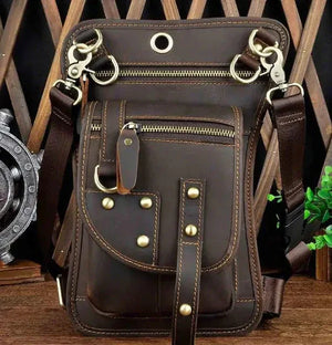 Dark brown leather crossbody bag with gold studs, multiple zippers, and adjustable strap