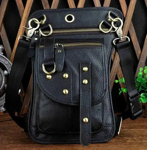 Black leather crossbody bag with gold studs, zippers, and adjustable strap