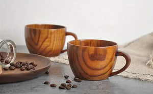 Wooden coffee cups with natural grain, coffee beans on plate, rustic table setting