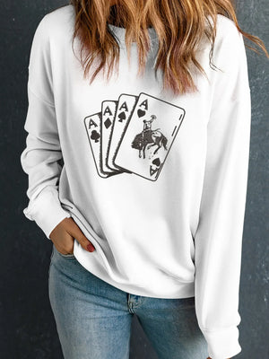 Woman wearing white sweatshirt with playing cards and cowboy graphic, casual fashion style