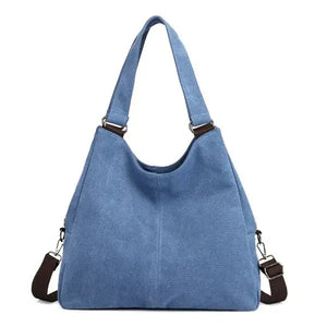 Light blue canvas shoulder bag with detachable brown strap and metal hardware
