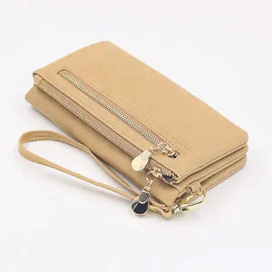 Beige leather wallet clutch with wrist strap, zippered pocket, and gold-tone zipper pull