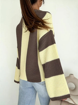 Woman in a loose fit, brown and cream striped knit sweater with light blue jeans