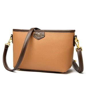 Tan leather crossbody bag with brown strap and gold-tone hardware on white background