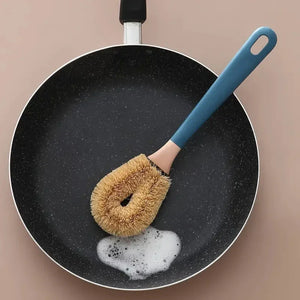 Nonstick frying pan with cleaning brush and soap suds, kitchen essentials
