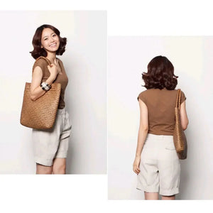 Woman wearing a brown top, light shorts, and carrying a woven tote bag