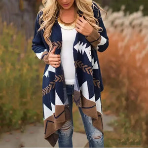 Woman wearing a geometric patterned open cardigan with jeans and a white top outdoors