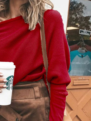 Woman in ribbed red sweater and brown skirt holding coffee cup outdoors