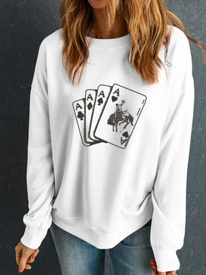 Woman wearing white sweatshirt with four aces playing cards and horse rider graphic, casual style