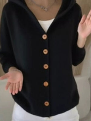 Woman wearing a black button-up cardigan with hood and white inner top