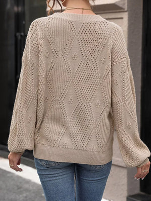Woman wearing beige knit sweater with textured diamond pattern and blue jeans outdoors