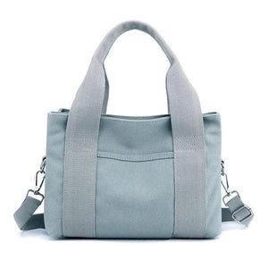 Light blue canvas tote bag with front pocket, sturdy handles, and detachable shoulder strap