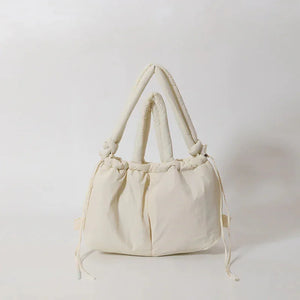 Cream puffy tote bag with knotted handles and drawstring details, soft fabric style