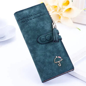 Green faux leather wallet with tassel, umbrella charm, and snap closure on white background