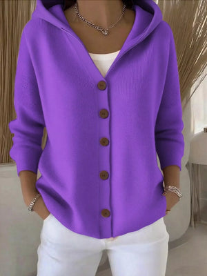 Woman wearing purple hooded cardigan with brown buttons and white pants