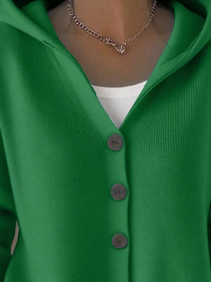 Green button-up cardigan with hood, layered over white top, chain necklace visible