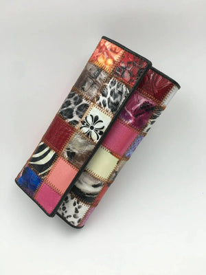 Colorful patchwork leather wallet with animal print and geometric patterns on white background