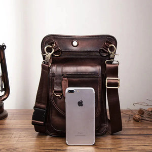 Brown leather crossbody bag with multiple zippers and an iPhone for size reference