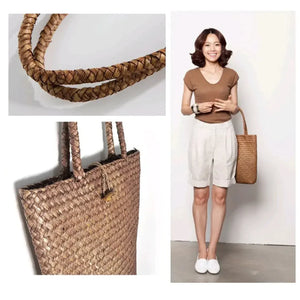 Woman carrying a woven straw tote bag with braided handles, natural fashion accessory