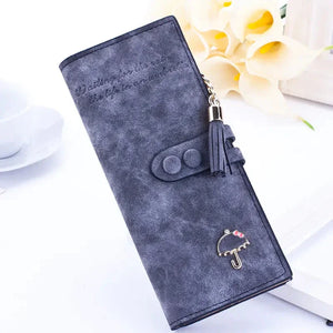 Gray faux leather women’s wallet with tassel keychain and umbrella charm on white background