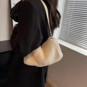 Woman in black blazer carrying white faux fur shoulder bag indoors
