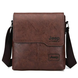 Brown leather crossbody messenger bag with flap, black Jeep Yuke logo, adjustable shoulder strap