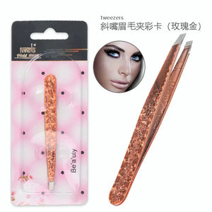 Rose gold slant tip eyebrow tweezers with floral design in pink packaging.