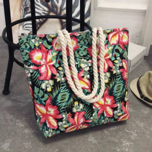 Floral print beach tote bag with rope handles on a gray floor