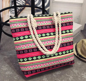Colorful boho tote bag with floral patterns and thick rope handles on a concrete floor