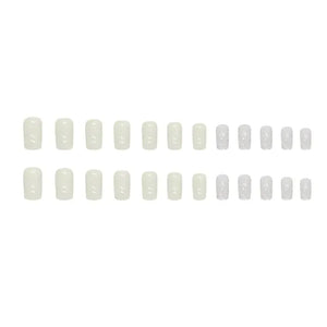 Set of glossy white and glittery press-on nails arranged in rows on a white background