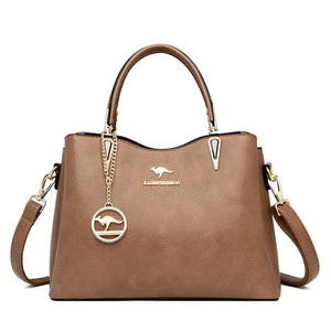 Brown leather handbag with dual handles, gold hardware, detachable strap, kangaroo logo charm
