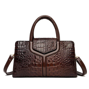Elegant brown crocodile-embossed leather handbag with top handles and removable strap