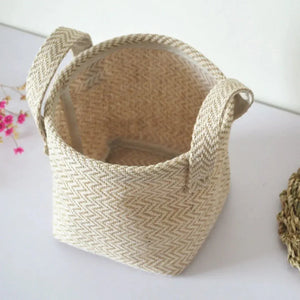 Natural woven basket with handles, beige zigzag pattern, on white surface