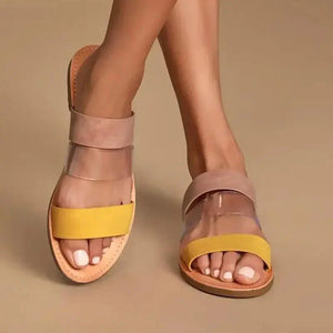 Woman wearing open-toe sandals with yellow and transparent straps on beige background