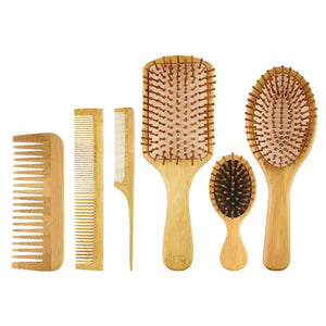 Set of six bamboo hair brushes and combs on white background