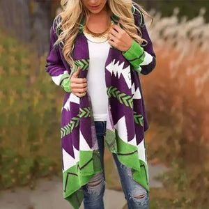 Woman wearing a purple and green geometric patterned cardigan, white top, ripped jeans