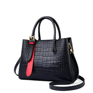 Black crocodile-embossed leather handbag with red accent and gold hardware