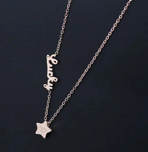 Gold necklace with 'Lucky' pendant and star charm on black background