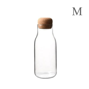 Clear glass storage bottle with cork lid, medium size, on white background