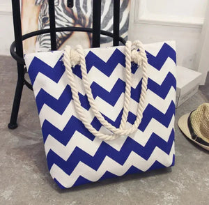 Blue and white chevron tote bag with rope handles on a concrete floor