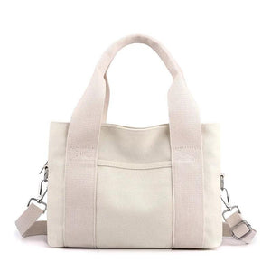 Beige canvas tote bag with front pocket, shoulder strap, and sturdy handles
