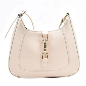 Beige leather shoulder bag with gold hardware and adjustable strap on white background