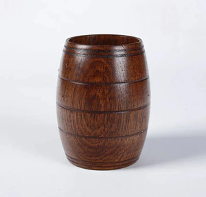 Wooden barrel-shaped cup with natural wood grain and smooth finish on a plain background