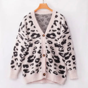 Fuzzy white cardigan with black leopard print and brown buttons on hanger