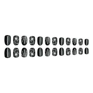 Set of black press-on nails with white skull, arrows, and stitched line designs