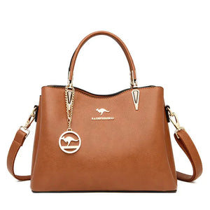 Brown leather handbag with gold hardware, top handle, detachable strap, and kangaroo logo charm