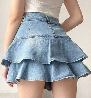 Woman wearing a layered ruffled denim mini skirt and white top, casual fashion style