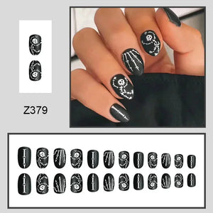 Black press-on nails with white skeleton and bone designs, matte finish