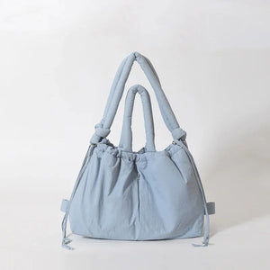Light blue puffy fabric handbag with drawstring and knotted double handles