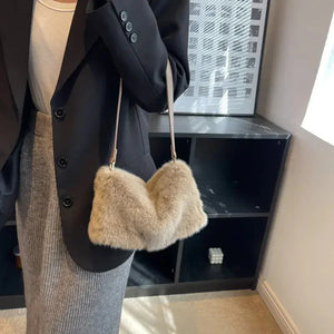 Woman wearing a chic outfit with a beige faux fur shoulder bag indoors